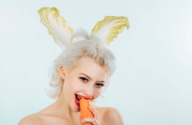 Tavşan kulaklı güzel genç bayan arka planda havuç yiyor. Anlaşıldı. Paskalya tatili