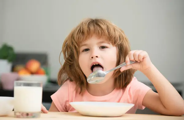 stock image Portrait of cute child eating soup meal or breakfast having lunch by the table at home with spoon. Kids healthy food