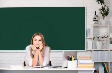 Sınıfta okuyan genç bir üniversite öğrencisinin portresi. Tahta altyapısı var. Okula geri dön.