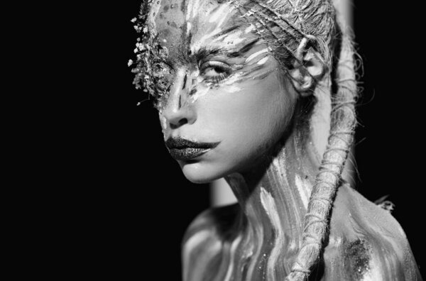 Искусство. Художественный портрет молодой женщины с художественным макияжем. Боди-арт. Абстрактная краска лица. Модель с креативным макияжем. Креативная краска тела и прическа. Женщина в краске. Привлекательный женский рисунок лица