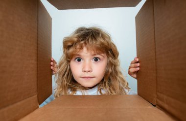 Sürpriz çocuk kutuları açıyor, kutuları açıyor ve içine bakıyor. Paket, teslimat, sürpriz, çocuklara hediye konsepti. Çocuklar için karton kutu açıyorum.