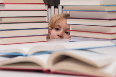 Eğitim Konsepti. Çocuk inek öğrenci kütüphanede kitap okuyor. Sınıfta kitabı olan bir öğrenci. Okumak için edebiyat. Çocuk kitaplardan öğreniyor. Okul eğitimi ve zeki yetenekli küçük dahi.