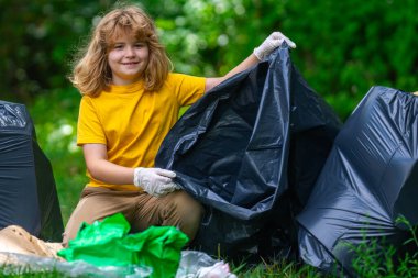 Çocuk dışarıda plastik şişe topluyor. Çevreyi koru ve atık kavramını azalt. Geri dönüşüm atıkları, çöp çöpleri, çöpler temizlenecek. Ekoloji konsepti. Çevre plastik kirliliği