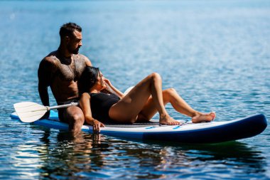 Suyun içinde birbirini kucaklayan bir çift. Denizde öpüşen romantik bir çift. Yaz kumsalında seksi çift kucaklaşması. Aşk ve aşk çifti. Aşık kaslı İspanyol erkek ve kadın
