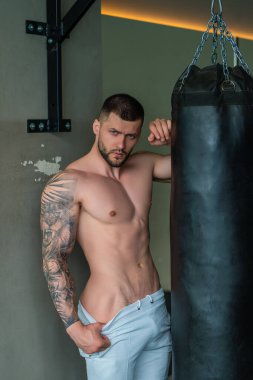 Spor salonunda kaslarını şişiren yakışıklı, kaslı, beyaz bir adam. Fitness ve vücut geliştirme sporu. Spor salonunda dambılı olan vücut geliştirici, sıkı çalışma.