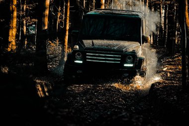 Yol dışı dağ yolunda yolculuk. Çamurda iz sürmek. 4x4 off-road SUV arabası. Lastikler yarışa hazırlanıyor. Offroad vagonu. Safari. Off-road yarışında çamur ve su sıçraması. En iyi off road araçları