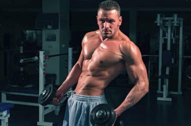 Vücut geliştirme egzersizleri. Dambıl egzersizi. Altı paketli erkek gövdesi. Çıplak vücutlu sporcu