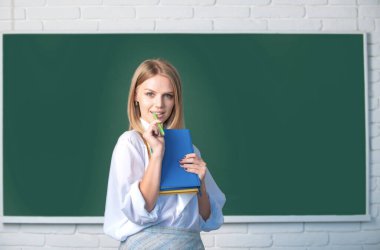 Female student on lesson lecture in classroom at high school or college. Female student taking notes from a book in college