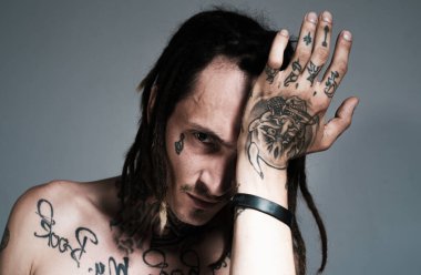 Ciddi yüzlü yakışıklı bir adamın portresi. Dövmeli ve zarif bir hippi. Hippi adam.