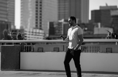 Şehirdeki adam Tampa 'da telefonla konuşuyor. Amerikan şehrinde sıradan giyinmiş, telefonda konuşan çekici bir adamın portresi. Dışarıda telefon kullanan yakışıklı bir genç. İş telefonu görüşmesi