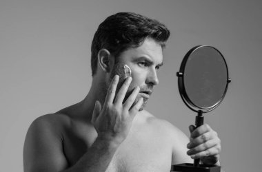 Cilt bakımı. Güzel orta yaşlı bir adam yüz kremi sürüyor. Erkek spa yüz kremi. Yüz kremi, nemlendirici, besleyici krem kaldırma. Yüz kremi cilt bakımı için. Kırışık kozmetik yüz tedavisi