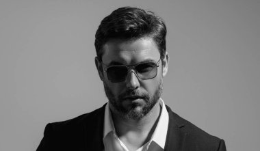 Gri stüdyodaki iş adamı izole edilmiş. Takım elbiseli zengin adam, stüdyo portresi. Başarılı bir iş adamı. Finansal başarı. İş adamı başarılı anlaşma