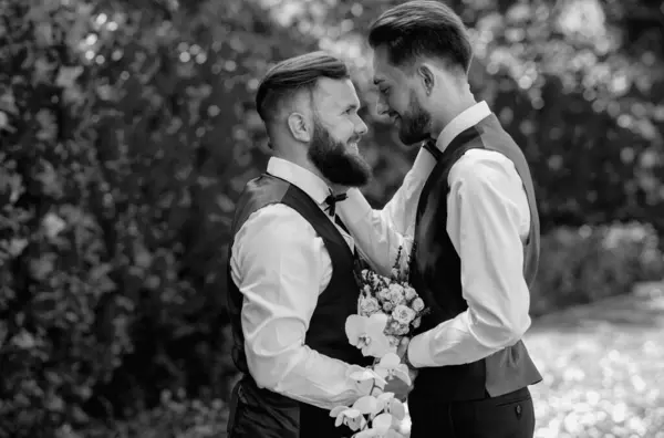 stock image Gay man with partner on wedding day. Married LGBT couples celebrate a romantic wedding ceremony together with a bouquet flower. Portrait of happy gay couple on their wedding day outdoor