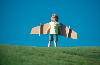 Gökyüzünde pilotçuluk oynayan çocuk mavi arka planda. Çocuk rüyası. Çocuk oyuncak jetpack ile oynuyor. Çocuk pilot parkta eğleniyor. Başarı, yenilik ve çocuk lideri başlangıç konsepti