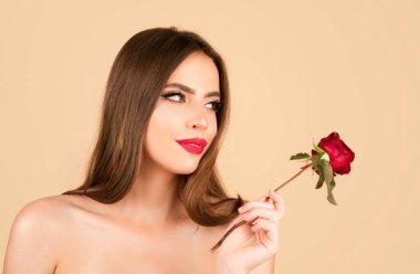 Güzel kadın yüzü ve çiçek. Kız ve gül. Yakın plan portre, cilt bakımı, makyaj