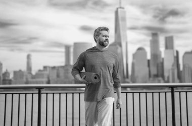 Spor formundaki adam New York 'ta spor yapıyor. Fitness adamı. Sporcu, kardiyo için antrenman yapıyor. Spor salonu açık havada. Adam dışarıda çalışıyor. New York parkında aktif yaşam tarzını seven bir adam.