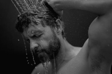 Saçlarını şampuanla yıkayan adamın portresi. Saçını şampuanla yıkıyorsun. Adam saçlarını kepek önleyici şampuanla yıkıyor, duş alıyor. Saç bakım ürünü, köpük jöle, şampuan ve losyon.