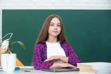 Tahtanın yanındaki kız öğrenci. Okul ve öğrenciler sınıfta. Eğitimli çocuklar. Okul sınıfındaki çocuk öğrenci. Öğrenim ve öğrenim kavramı