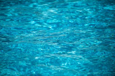 Su arka planı, dalgalanma dalgaları. Mavi yüzme havuzu deseni. Deniz yüzeyi. Yüzme havuzunda su ve güneş yansıması. Kopyalama alanı olan pankart