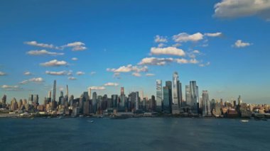 New York 'taki Manhattan ve One World Trade Center Weehawken New Jersey' den görüldüğü gibi. Manhattan 'ın gökdelenleri New York körfezinin dalgalanan sularının yanında mavi gökyüzüne karşı. NYC, ABD