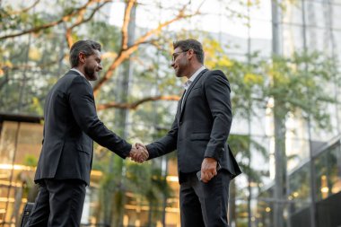 Dışarıda el sıkışan iki işadamı. El sıkışıyoruz. Yönetim stratejisi. İki işadamı arasında tokalaşma. İş konsepti iletişimi. Selamlama, anlaşma, birleşme ve kazanç