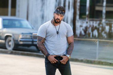 Sokaktaki vahşi moda adamı. Acımasız adamın moda portresi. Güçlü kaslı erkek, kaslı adam. Seksi bir adam. Moda erkek modeli, Vogue sokak tarzı. Bandana 'da dövmeli bir moda adamı.