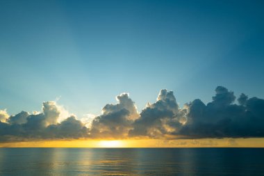 Gün batımı denizi. Bulutların arasından gün batımını izleyen sakin bir deniz. Meditasyon okyanusu ve gökyüzü arka planı. Huzurlu deniz manzarası. Günbatımı deniz suyunun üzerinde bir ufuk. Gün batımı gökyüzü sakin