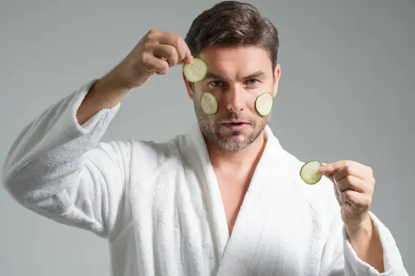 stock image Beauty man hold cucumber for cosmetology mask. Middle aged man with cucumber isolated on studio background. Cucumber for cosmetics skin mask. Facial mask with cucumber