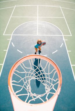 Basketbol oynayan ve mutlu yüzlü bir çocuk.