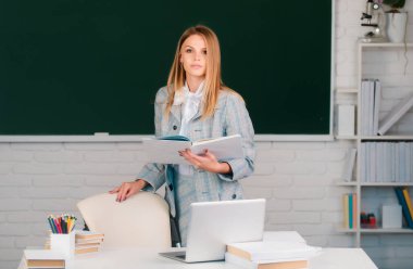Female student preparing exam and learning lessons in school classroom