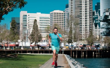 San Diego 'daki şehir parkında koşan genç bir atletik. Atletik genç adam koşuyor. Spor ve sağlıklı yaşam tarzı