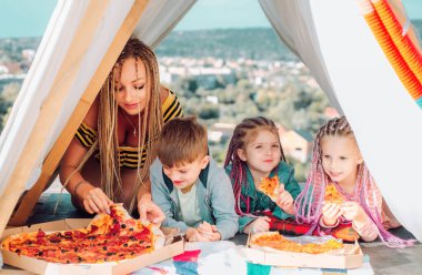 Family pastime. Mother with children playing together. Eating pizza. Family camping. Mom with kids. Summer vacation concept. Mothers day clipart