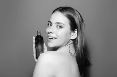 Stüdyoda parfüm şişesi olan kadın. Parfümlü bir kız, elinde bir şişe parfüm ve güzel kokan bir kadın. Parfümlü şehvetli manken. Güzellik parfümü. Parfüm şişesi ve parfümü.