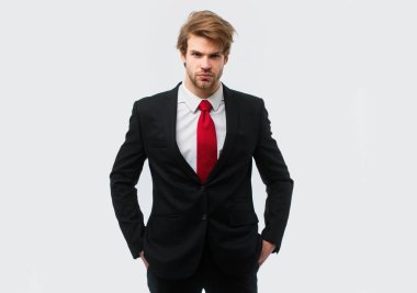 Beyaz arka planda elleri cebinde resmi takım elbiseli bir adam var.