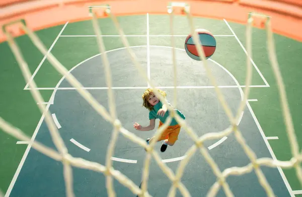 stock image Child shooting Basketball ball and playing basketball, lower view wide angle. Basketball kids training game. Basketball kids school