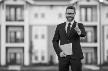 Ev geçmişinde dizüstü bilgisayar kullanan bir iş adamı. Dışarıda bilgisayarlı bir erkek işadamı var. İş adamı dizüstü bilgisayarı tutar. Gözlüklü beyaz iş adamı dizüstü bilgisayarla çalışıyor.