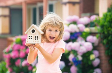 Heyecanlı çocuk yeni bir rüya evi yapıyor. Genç bir aileye ev sahipliği yapmak. Hayret bir çocuk yeni bir ev hayal ediyor.