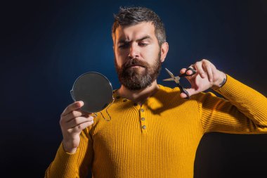 Berber makası ve ayna, berber dükkanı. Berber makasıyla bıyık ve sakal kesmek. Tıraş olmadan sakallı adam. Erkek güzeli. Sakal bakımınla gurur duy. Sakal bakımı