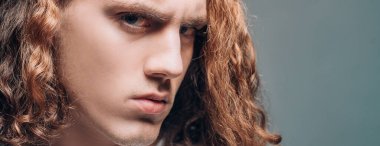 Gri arka planda gergin bir genç adam. Sportif, yakışıklı, güçlü, sportif, baştan çıkarıcı, kendine güvenen bir adamın kesilmiş fotoğrafı. Ciddi bir adamın portresi. Kendine güvenen bir konsept. Kentsel yaşam tarzı konsepti