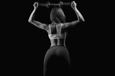 Atletik kadın halterlerle kaslarını şişiriyor. Kadın spor vücudu güçlü ve sırt üstü. Kadın çıplak kaslı sırt. Güçlü kadın dambıllarla çalışıyor. Sportif seksi kaslı sırt.