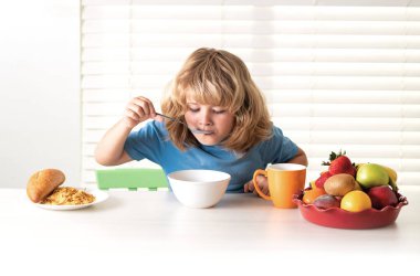 Çocuk robot yemek yiyor. Çocuklar için sağlıklı beslenme. Çocuk kahvaltıda ya da akşam yemeğinde iştahla yemekten hoşlanır. Aç çocuk lezzetli meyve ve sebze yer.