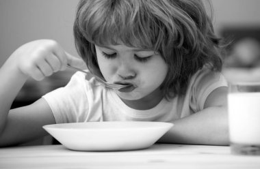 Çocuk yer. Küçük sağlıklı aç çocuk kaşıkla çorba içiyor.