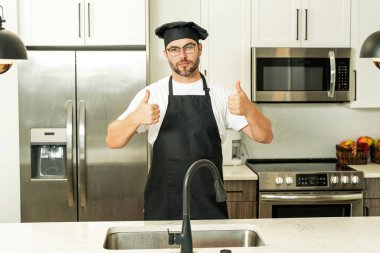 Aşçı, aşçı ya da fırıncı portresi. Aşçı şapkalı ve aşçı üniformalı adam mutfakta yemek pişiriyor.