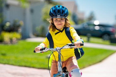 Küçük çocuk parkta bisiklete biniyor. Bisikletli bir çocuk. Bisiklet süren kasklı mutlu çocuk. Çocuk bisiklete binmeye başladı. Bisikletli bir çocuk bisiklet sürüyor. Çocuk bisikleti