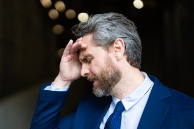 Üzgün iş adamının migreni tuttu. Güçlü baş ağrısı olan bir adam. Stresli, baş ağrısından yorgun iş adamı. Baş ağrısı, yorgunluk ve stres, migren. Baş ağrısı konsepti