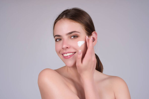 Beautiful woman applying moisturizer cream her face. Beauty concept. Skincare and pampering. Anti aging cream. Young model applyed cream. Girl applying cosmetic cream treatment on face
