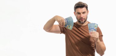 Beyaz afiş üzerinde izole edilmiş para tutan yakışıklı bir adam. Dolar banknotları halinde para. Yığınla para, finans, yatırım ve tasarruf. Kredi, para ve kazançların maketi