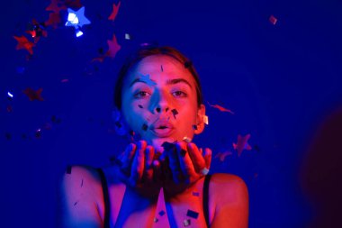 Konfeti üfleyen seksi kadın. Doğum gününde güzel bir genç kadın, sevgililer günü. Romantik seksi kadın doğum gününde ışıltı saçar. Doğum gününü kutlayan kadın. Sevgililer günün kutlu olsun. Doğum günü partisi