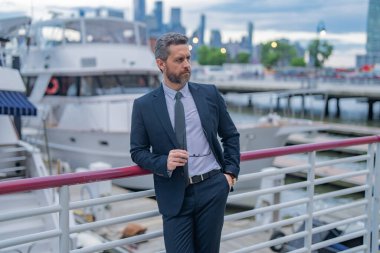 Takım elbiseli başarılı bir iş adamı New York 'ta açık havada poz veriyor. İş dünyası Amerikan başarısı. Amerikan iş rüyası. Başarı Amerikan işi. Yatın yanında takım elbiseli bir iş adamı. Başarı işi