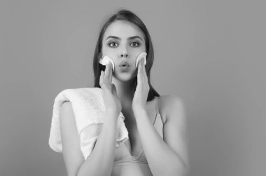 Woman removing makeup, holds cotton pads. Cleansing treatment care for skin with cotton pad. Young woman beauty model applying skin care product using a cotton pad